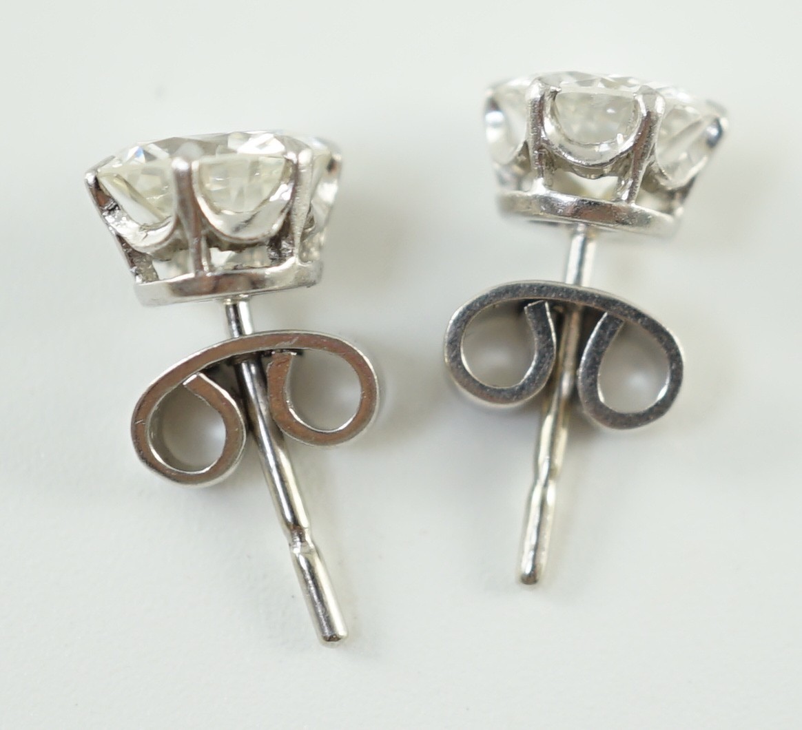 A pair of white gold and solitaire diamond set ear studs